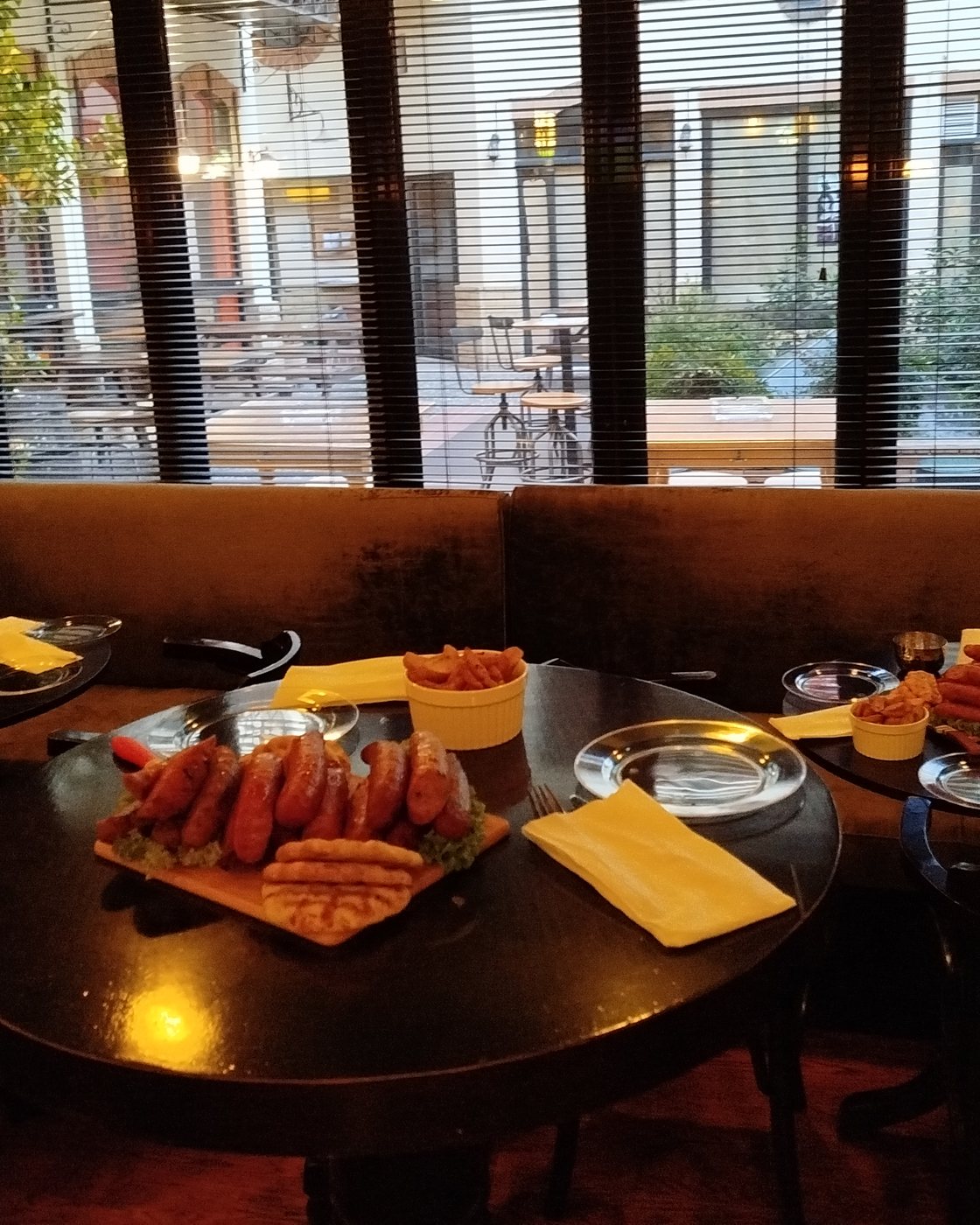 A platter of sausages on the table, the shop&rsquo;s garden through the window behind
