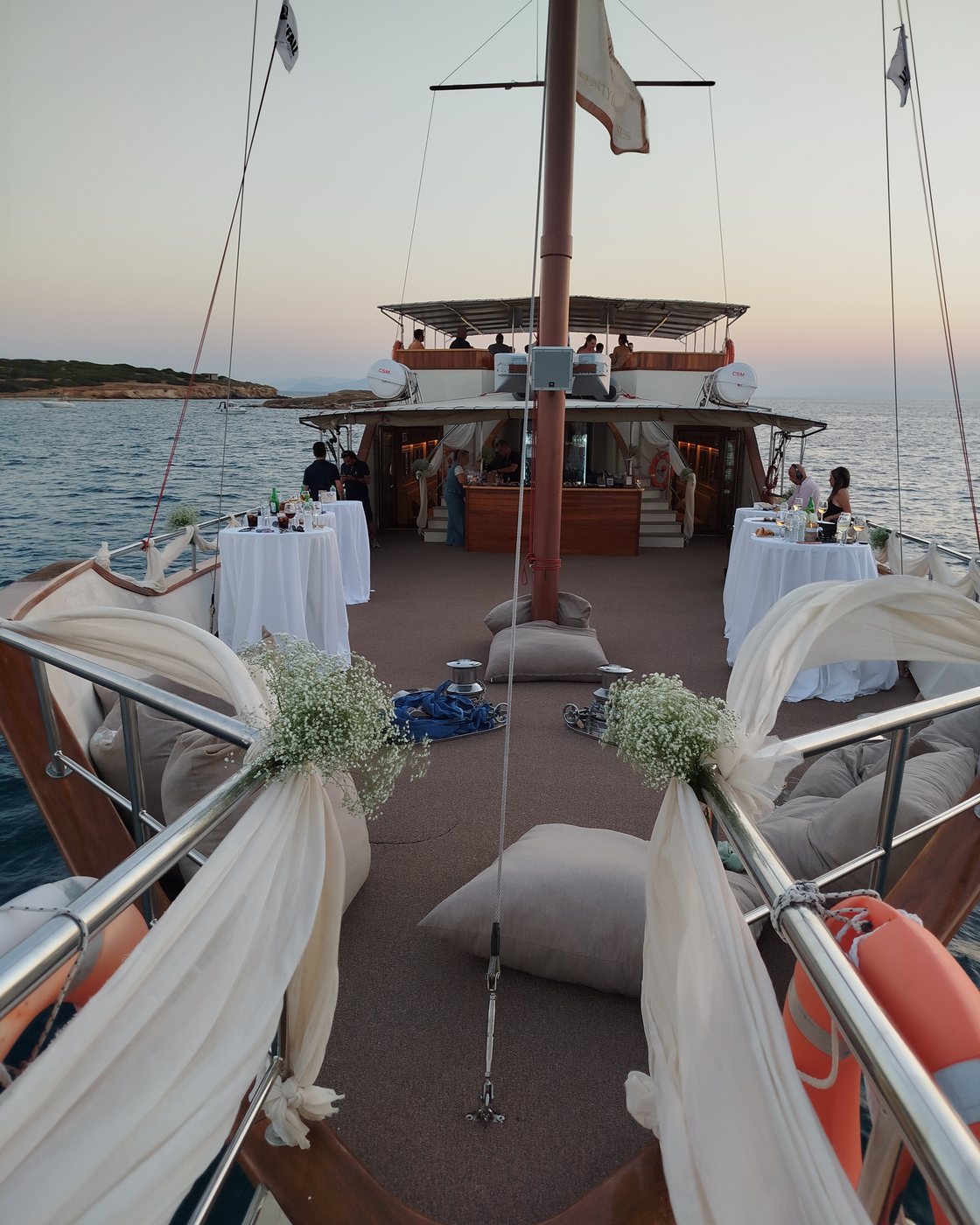 The deck dressed for a wedding: white running along the rails, gypsophila at the shrouds, tables laid on the foredeck