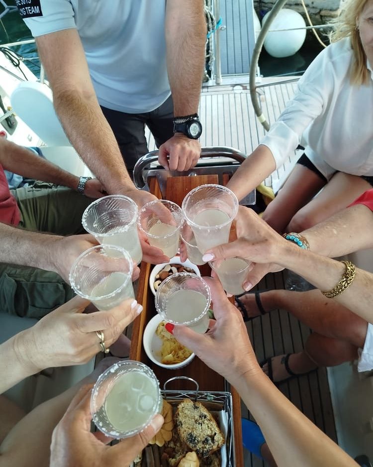 Eight hands meeting over the table to touch glasses