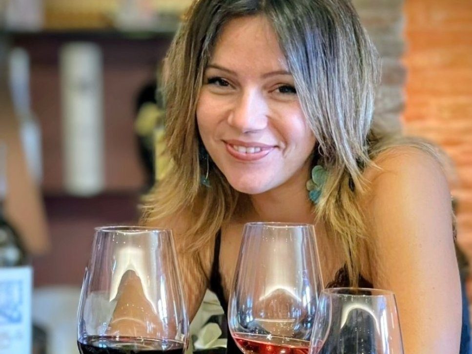 Maria at the tasting table, three glasses poured in front of her: red, ros&eacute; and white